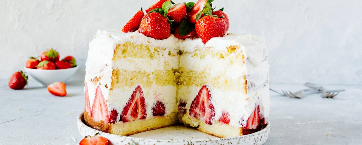 Erdbeer-Sahne-Torte auf Teller mit Geschirrhandtuch