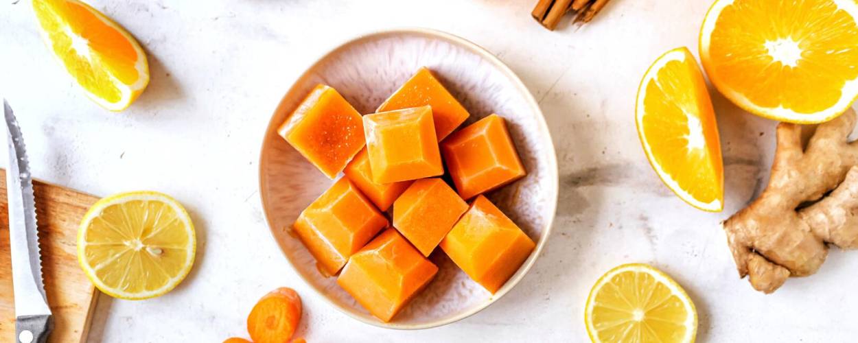 Orangen, Orangensaft, Zimtstangen und orange Eiswürfel