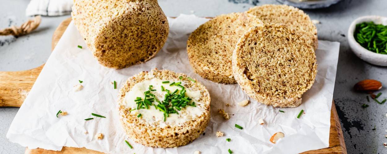 Rundes Brot angeschnitten auf Holzbrett mit Aufstrich