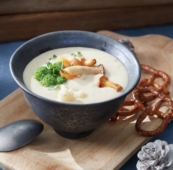Suppenschüssel mit Gemüse und heller Cremesuppe