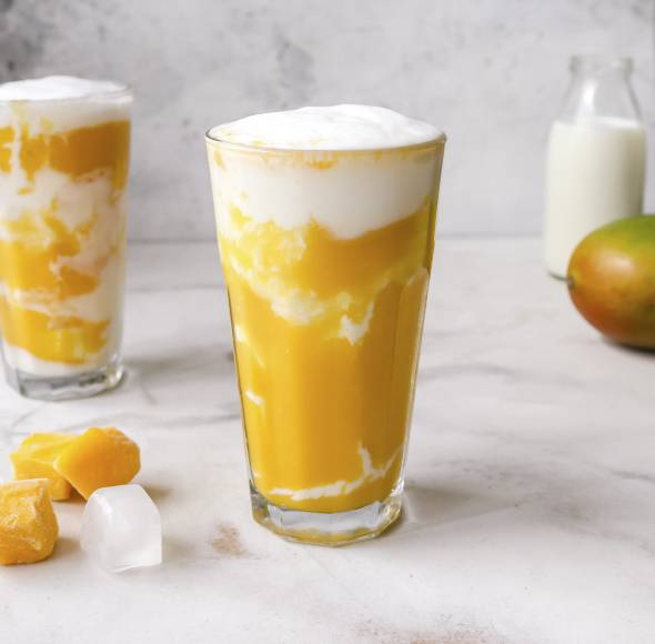 Mangoüpürree mit weißer Creme geschichtet im Glas