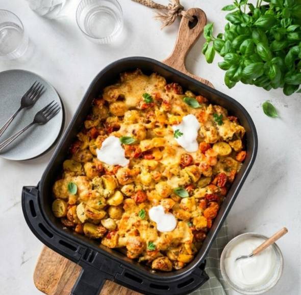 Airfryer-Feierabendblech mit Ofenkartoffeln auf Holzbrett von oben fotografiert