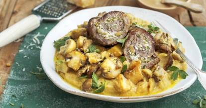 Rinderroulade mit Kräuter-Ricotta-Füllung mit Pilzen auf weißem Teller