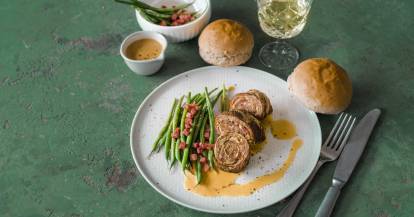 Rouladen mit Bohnen und Speck auf Teller mit Deko
