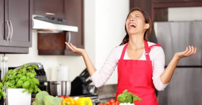 Eine Frau hebt verzweifelt die Hände in der Küche