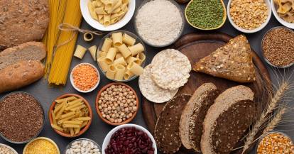 Verschieden kohlenhydrathaltige Lebensmittel verteilt auf einem Tisch