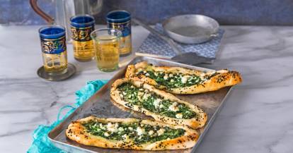 Spinat-Pide auf Blech mit Tee in Gläsern