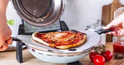 Fertige Pizza wird aus dem G3Ferrari Pizzaofen gehoben