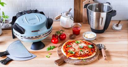 G3Ferrari Pizzaofen mit Zubehör, einer fertigen Pizza und dem Mixtopf auf einer Arbeitsfläche