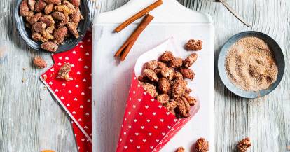 Gebrannte Mandeln in Tütchen, Schalen und auf einem Brett