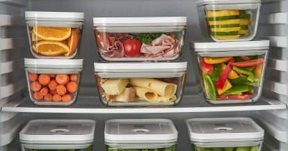 Lebensmittel in Aufbewahrungsboxen übereinander gestapelt im Kühlschrank