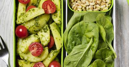 Kartoffelsalat mit Pesto, Tomaten, Spinat und Pinienkernen in Aufbewahrungsboxen