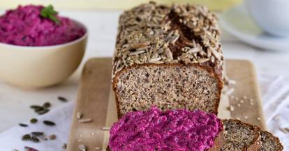 Gesundes Eiweißbrot angeschnitten und mit Rote-Bete-Creme bestrichen