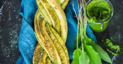 Hefezopf mit grünem Pesto und Bärlauch auf blauem Tuch