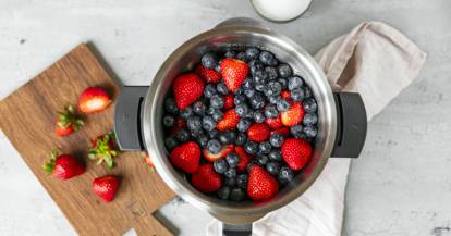 Blick in den Mixbehälter des Monsieur Cuisine gefüllt mit Heidelbeeren und Erdbeeren