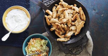 Gyros in einer Schale, daneben Zaziki und Krautsalat in Schälchen