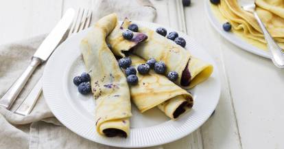 Pfannkuchen gerollt, mit Blaubeeren auf einem Teller