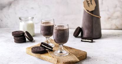 Zwei Gläser mit dunklem Creme-Likör, daneben Oreo-Kekse, im Hintergrund eine Flasche