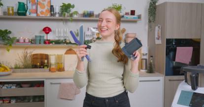 Junge Frau hält Monsieur Cuisine Zubehör in den Händen