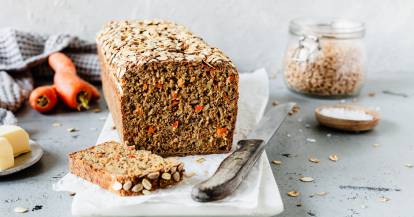 Fitnessbrot angeschnitten, eine Scheibe liegt davor, ebenso wie ein Brotmesser