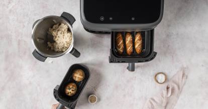 Philips Airfryer von oben, in den Schubladen Laugenstangen und -brötchen. Daneben der Mixbehälter des Monsieur Cuisine mit Teig.