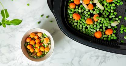 Gefrorene Erbsen und Karotten im Dampfgaraufsatz des Monsieur Cuisine. Von oben fotografiert