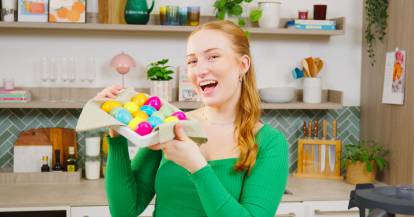 Isy hält einen Korb mit bunten Ostereiern