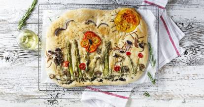 Focaccia von oben fotografiert, mit Gemüse belegt, das wie ein Garten angeordnet ist