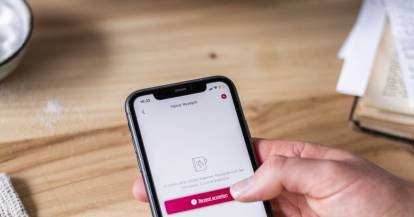 Jemand hält ein Smartphone, dahinter steht der Monsieur Cuisine