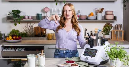 Frau steht in einer KĂŒche neben dem Monsieur Cuisine und hĂ€lt den Daumen runter