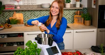 Junge Frau kocht mit dem Monsieur Cuisine