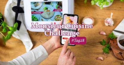 Eine Hand hält ein Smartphone, dahinter der Monsieur Cuisine. Challenge, Tag 28