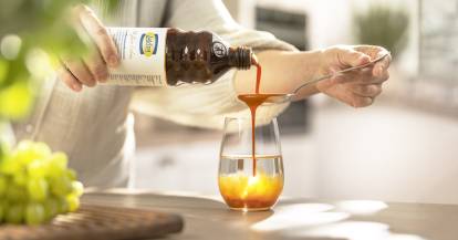 Jemand gießt LaVita auf einen Löffel über einem Glas