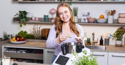 Junge Frau mit einem Monsieur Cuisine in einer Küche