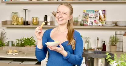 Junge Frau mit einer Schale in der Hand, in der ein Dip ist