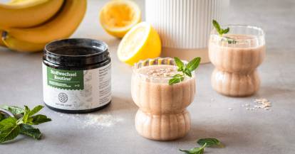 Zwei Gläser mit einem Smoothie, daneben Stoffwechsel Routine Produkt von Nature Love