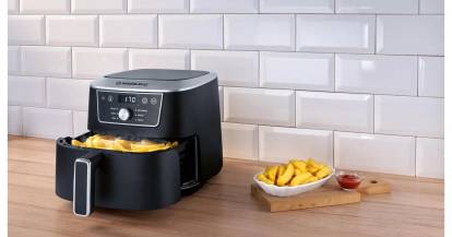 Airfryer mit Pommes in der geöffneten Schublade
