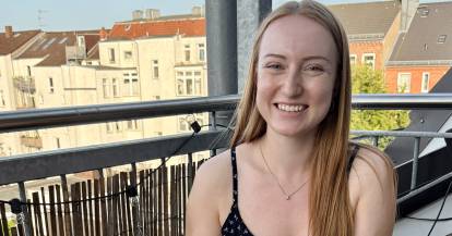 Junge Frau mit einem Teller auf einem Balkon
