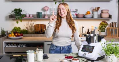 Junge Frau in einer Küche neben dem Monsieur Cuisine