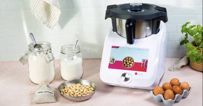 Monsieur Cuisine umgeben von Backzutaten, Mehl, Zucker, Mandeln, Eiern