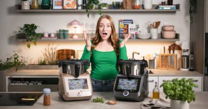 Frau in einer Küche mit überraschtem Gesicht. Vor ihr zwei Monsieur Cuisine