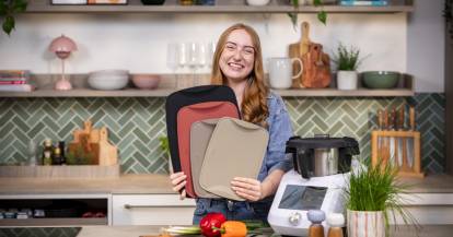 Frau mit Schneidebrettern und dem Monsieur Cuisine