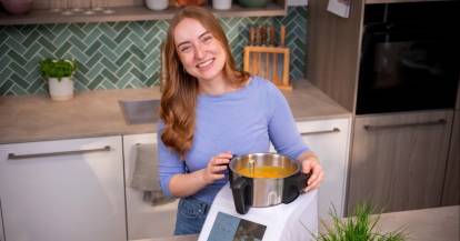 Eine Frau in einer Küche, neben dem Monsieur Cuisine, darin Kürbissuppe