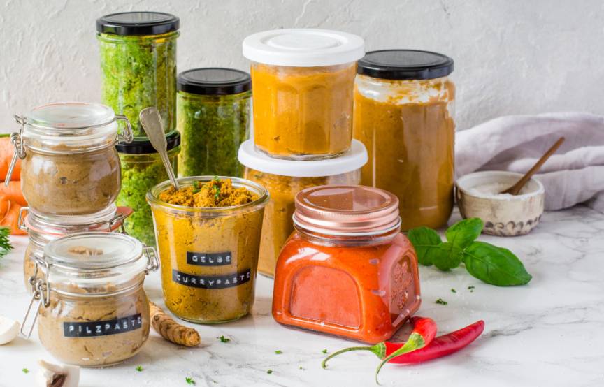 Unterschiedliche Gläser mit bunten Gewürzpasten