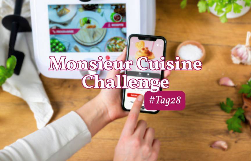 Eine Hand hält ein Smartphone, dahinter der Monsieur Cuisine. Challenge, Tag 28