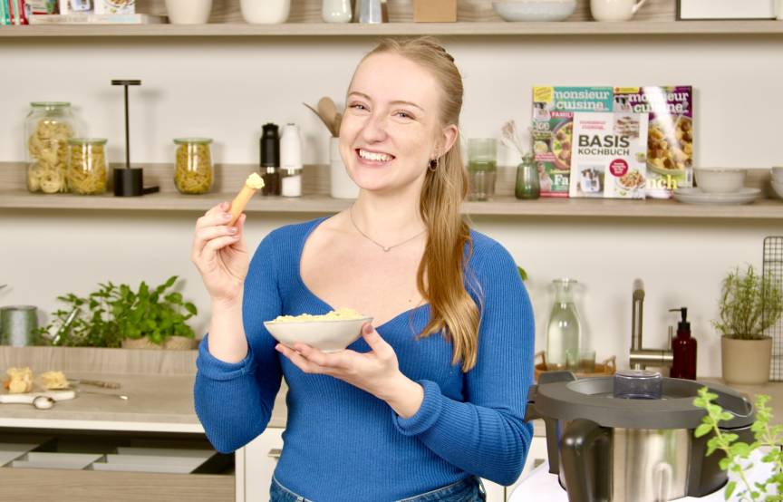 Junge Frau mit einer Schale in der Hand, in der ein Dip ist