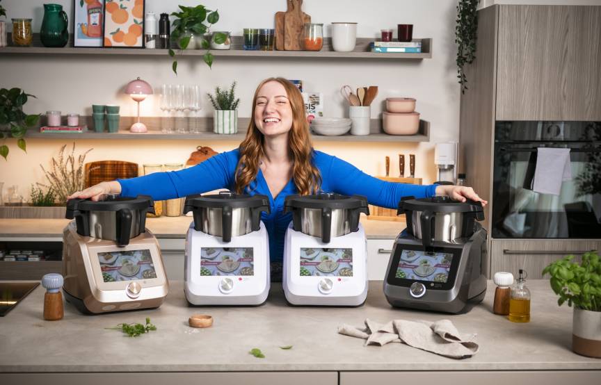 Junge Frau mit 4 Monsieur Cuisine Geräten in einer Küche