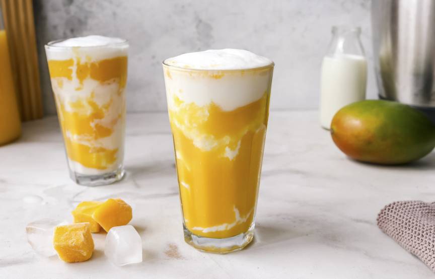 Mangoüpürree mit weißer Creme geschichtet im Glas