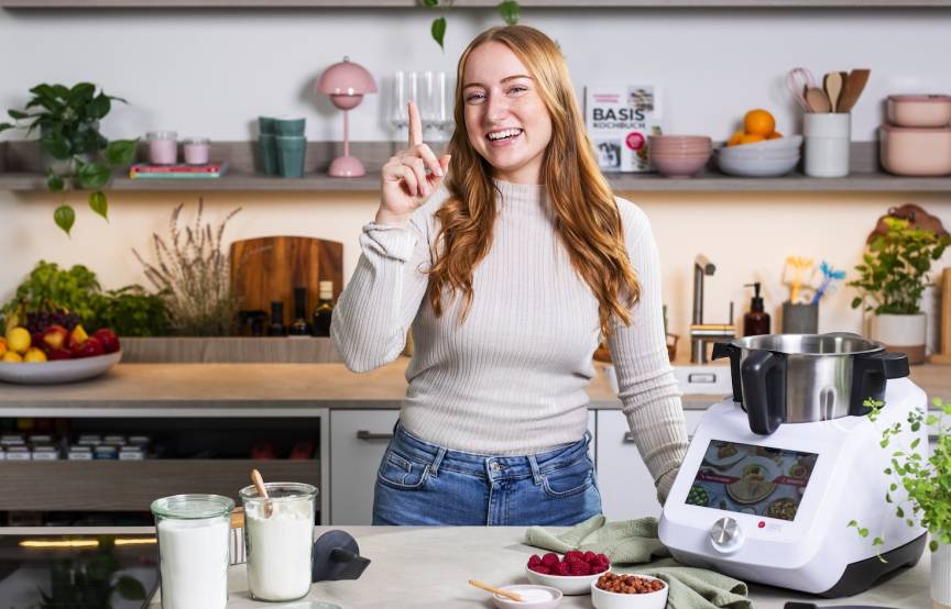 Junge Frau in einer Küche neben dem Monsieur Cuisine