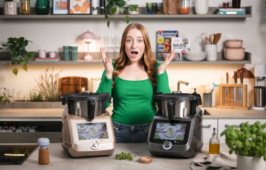 Frau in einer Küche mit überraschtem Gesicht. Vor ihr zwei Monsieur Cuisine